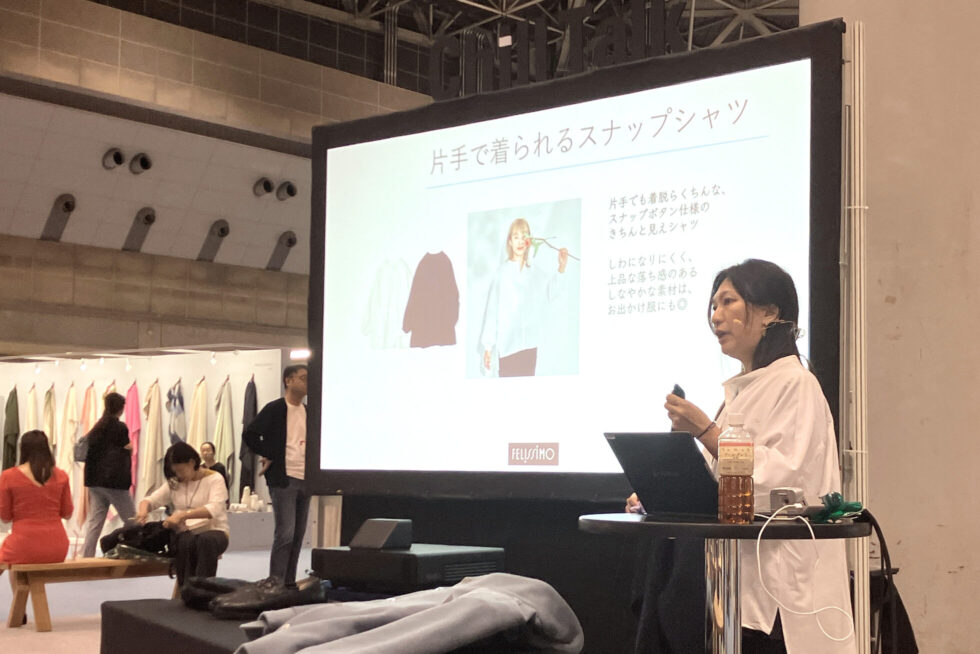 フェリシモ 筧さんがスライドを使ってプレゼンしている様子。手前の机には、One Hand Magicの製品が並べられている。